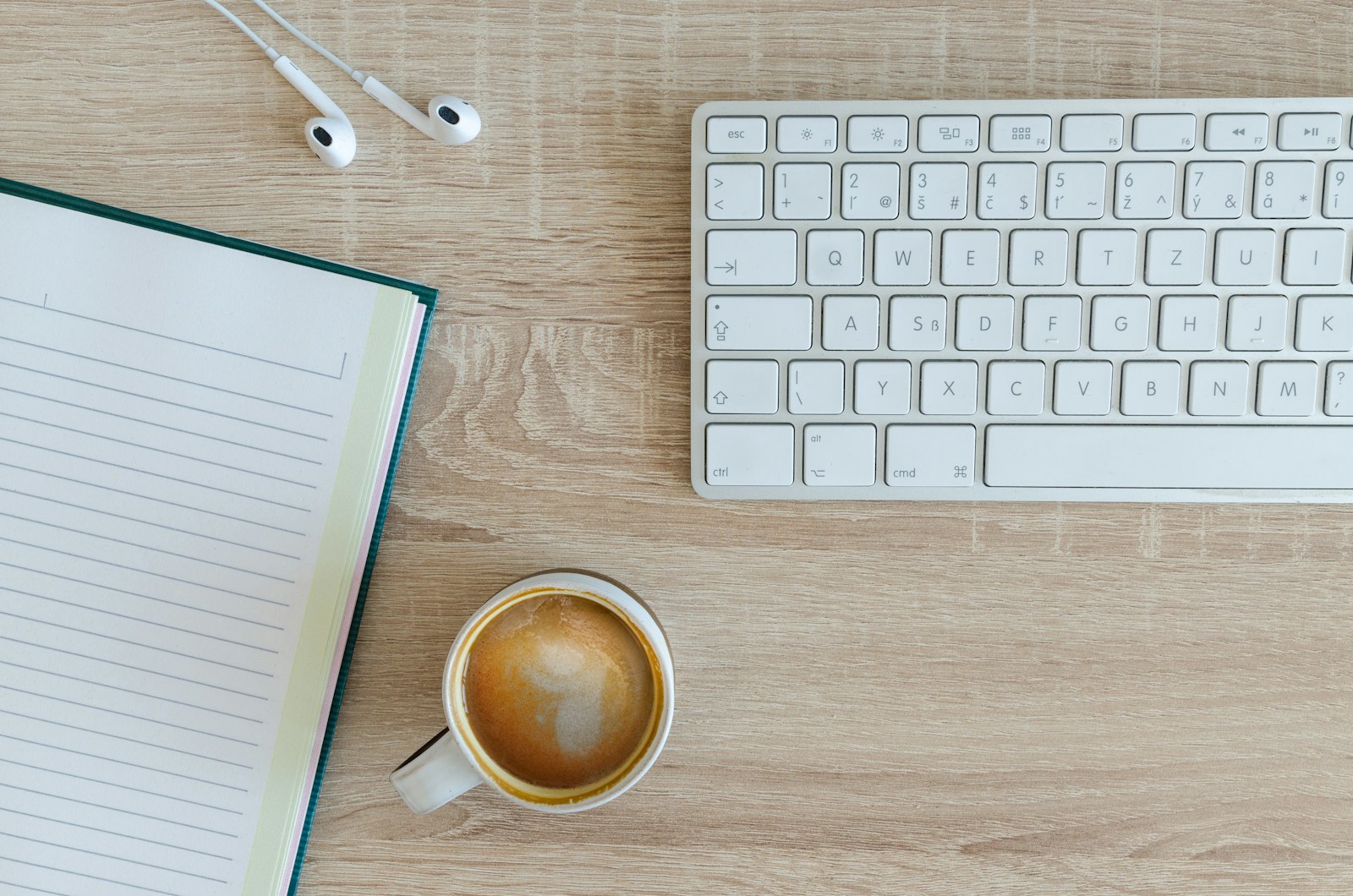 Carnet ouvert et café au lait sur un bureau clair